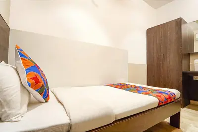 a bedroom with a bed with a pillow and a cabinet at FabHotel Karpagam - 900m from Nehru Stadium in Coimbatore