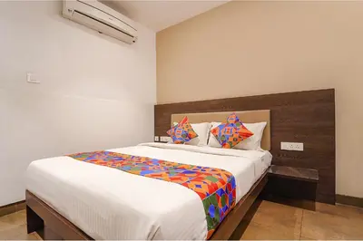 a bedroom with a large bed with a wooden headboard at FabHotel Karpagam - 900m from Nehru Stadium in Coimbatore