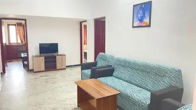 a living room with a couch and a tv at WHITE HOUSE - 3BHK Elegant Apartment in Coimbatore