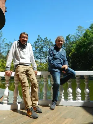 two men are sitting on a railing at Torch Ginger Homestay in Sultan Bathery