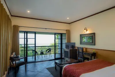 a hotel room with a bed and a balcony at The Hive, Wayanad in Wayanad