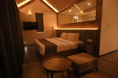a hotel room with a bed and a table and a chair at Chembarathi Wayanad Boutique Resort in Vaduvanchal