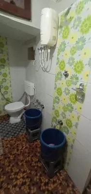 a bathroom with two blue toilets in a room at Nakshatra Homestay in Madikeri