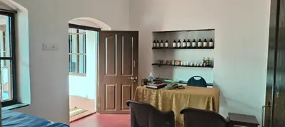 a room with a table with chairs and a door at Aramana Ayurvedic Wellness Centre & Homestay in Palakkad