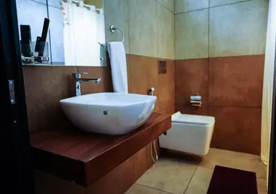 a bathroom with a sink and a toilet at Niyatma Wayanad Pool Resort by VOYE HOMES - Inside Coffee Plantation in Wayanad