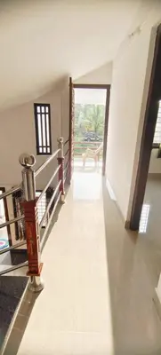 a hallway of a house with a staircase and a window at Johns Villa in Sultan Bathery