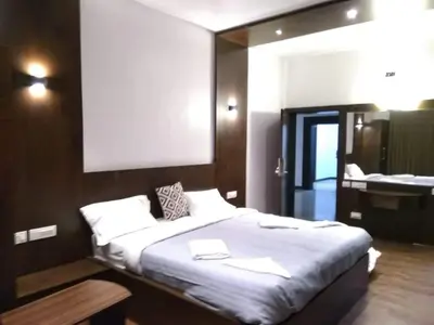 a bedroom with a large bed and a bathroom at Belair Resorts in Kotagiri