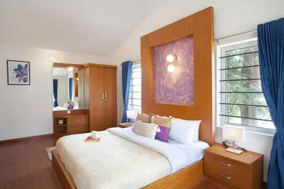 a bedroom with a large bed and a window at StayVista at Villa Misty Oaks with Breakfast in Ooty