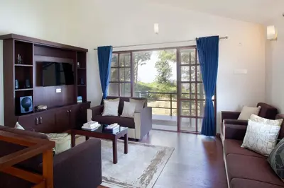 a living room with a couch and a tv at StayVista at Villa Misty Oaks with Breakfast in Ooty