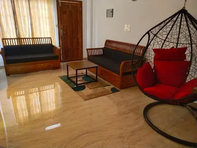 a living room with two couches and a swing at Casa Maria Mystica apartments, Mananthavady, Wayanad in Mānantoddy