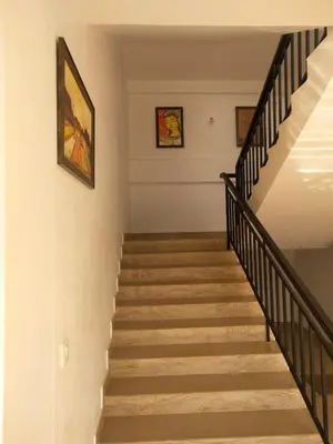 a staircase in a home with two pictures on the wall at Casa Maria Mystica apartments, Mananthavady, Wayanad in Mānantoddy