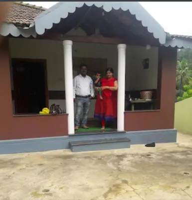 a man and a woman standing in the doorway of a house at Devarakadu Valley View by StayApart in Madikeri