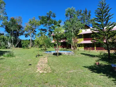 a house with a yard with a pool and trees at THE TIGER PAW RESORT in Masinagudi