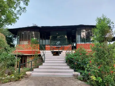 a staircase leading up to a building with a black roof at THE TIGER PAW RESORT in Masinagudi