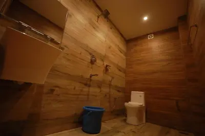 a bathroom with a toilet and a wooden wall at HYDEPARK REGENCY in Palakkad