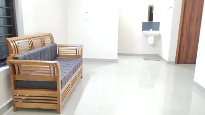 a wooden chair in a room with a toilet at Eve's appartment in Meppādi