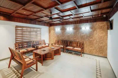 a room with wooden tables and chairs and a wall at Cherai Beach View Heritage in Cherai Beach