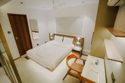 a small room with a bed and a chair at Alite Enclaves Fully furnished apartments in Trichūr