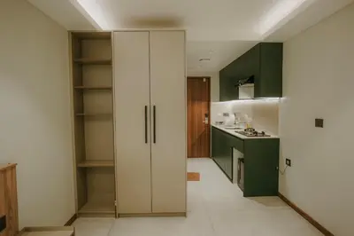 a kitchen with green cabinets and a large white closet at Alite Enclaves Fully furnished apartments in Trichūr