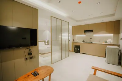 a living room with a television and a bathroom at Alite Enclaves Fully furnished apartments in Trichūr