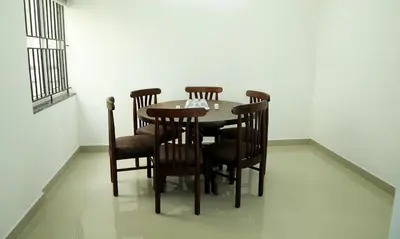 a dining room table and chairs in a room at Alite Enclaves Fully furnished apartments in Trichūr
