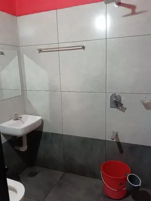 a bathroom with a sink and a glass shower door at CRS RED & WHITE HOMESTAY in Sultan Bathery