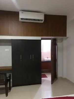 a black cabinet in a room with a window at Redbell suites Residency in Kondotti