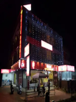 a large building with lights on it at night at Redbell suites Residency in Kondotti