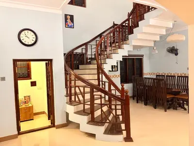 a staircase in a living room with a clock on the wall at 