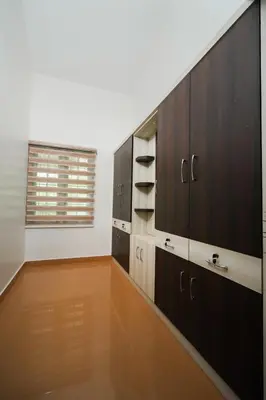 a kitchen with wooden cabinets and a window at Parudeesa - Heavenly- Luxurious Palace look-Near CBD - Kerala - India with Breakfast in Kāladi