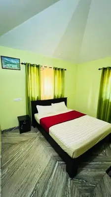 a bedroom with a bed with a red and white comforter at Golden Cypress Resort with Pool -Wayanad in Padinjarathara