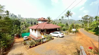 a house with a car parked in front of it at Golden Cypress Resort with Pool -Wayanad in Padinjarathara