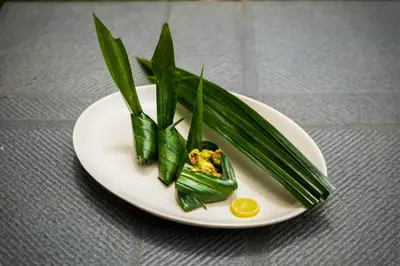 a plate of food with greens and a lemon at Sterling Vythiri Wayanad in Wayanad