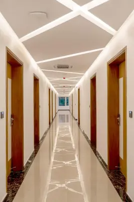a corridor in a building with a long hallway at Hotel Panoramic in Ernakulam