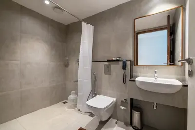 a bathroom with a sink and a toilet and a mirror at Hotel Panoramic in Ernakulam