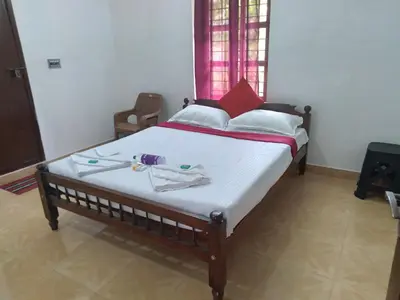 a bedroom with a bed with two towels on it at Homely Homestay in Kalpetta