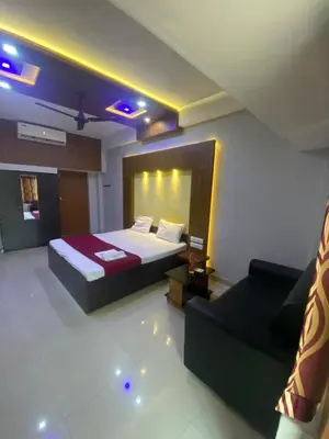 a hotel room with a bed and a couch at Redbell Suites Calicut in Kozhikode