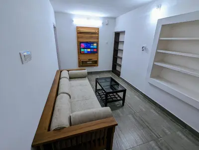 a living room with a couch and a tv at The Wayanad Club in Sultan Bathery