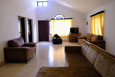 a living room with two couches and a television at The Wayanad Club in Sultan Bathery