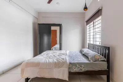 a bedroom with a bed and a window at Amminis Mansion by Doris Homes in Trichūr