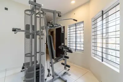 a gym with tread machines in a room with windows at Amminis Mansion by Doris Homes in Trichūr