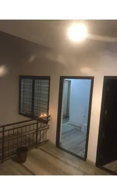a living room with a mirror and a balcony at Redbell Inn Airport Hotel in Kondotti