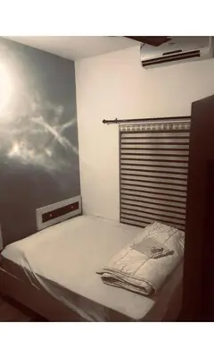 a bedroom with a bed with a blanket on it at Redbell Inn Airport Hotel in Kondotti