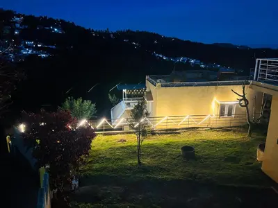 a house with lights on the side of it at night at Wander homes in Ooty