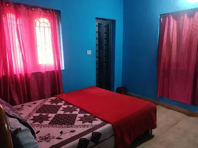 a bedroom with blue and red walls and a bed at Wander homes in Ooty