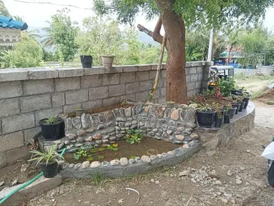 a retaining wall with a tree and a hose at BHASURI VILLA Attappady in Varagampadi