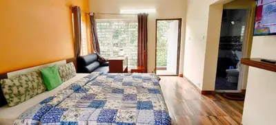 a bedroom with a bed and a bathroom with a window at Serenity inn - Rose Garden in Ooty