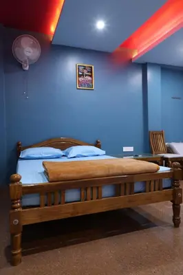 a bedroom with a wooden bed with a blue wall at Ammukutty's Cottage in Munnar