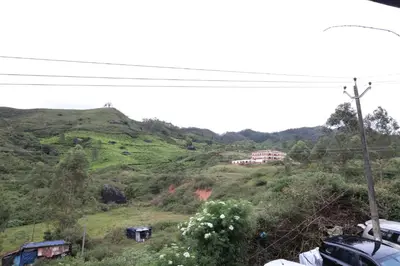 a view of a hill with a house on it at Ammukutty's Cottage in Munnar