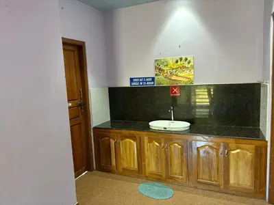 a bathroom with a sink and a black counter top at Ammukutty's Cottage in Munnar
